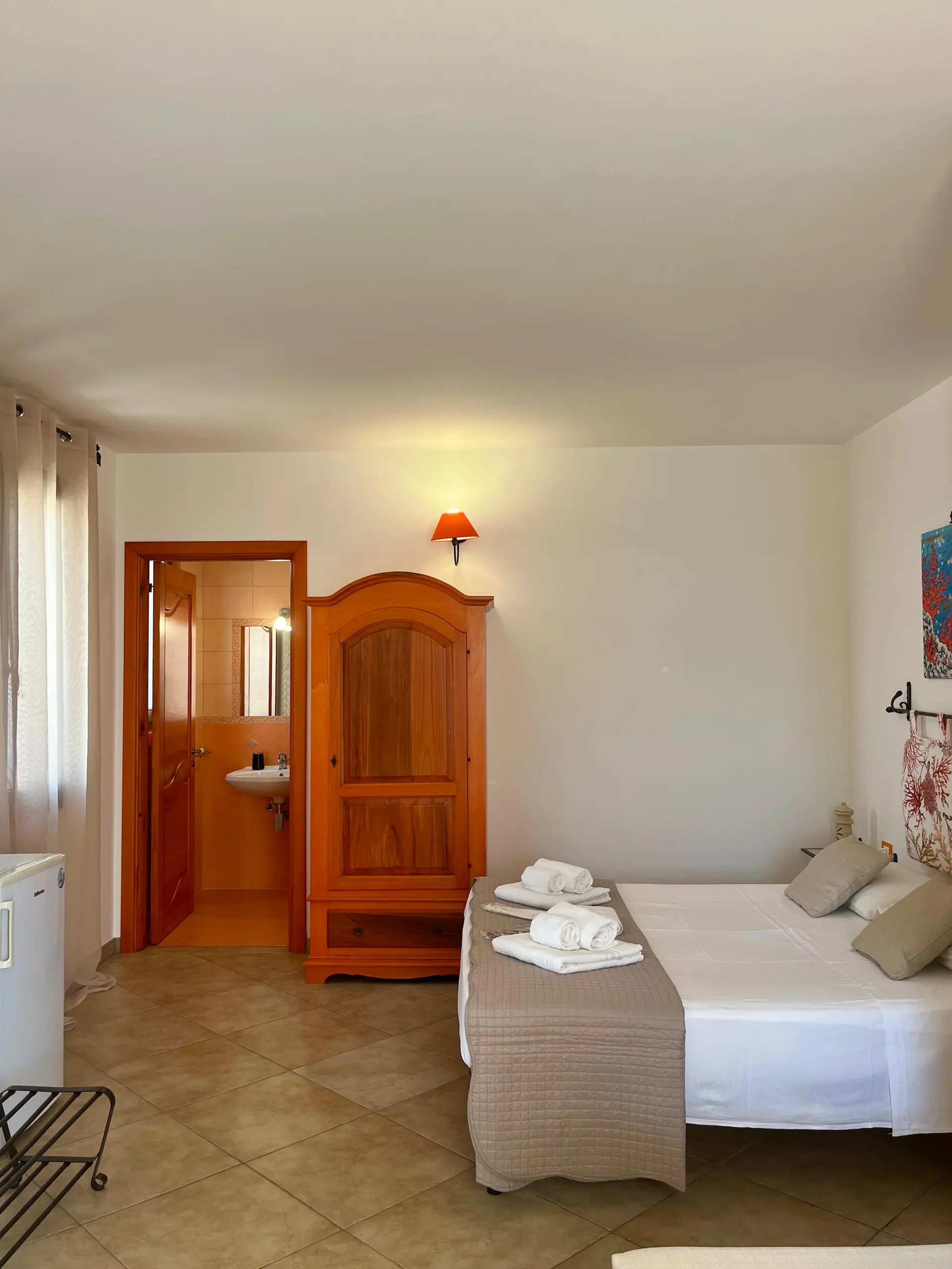 Stanza Corallo, con arredi arancioni, armadio e letto matrimoniale